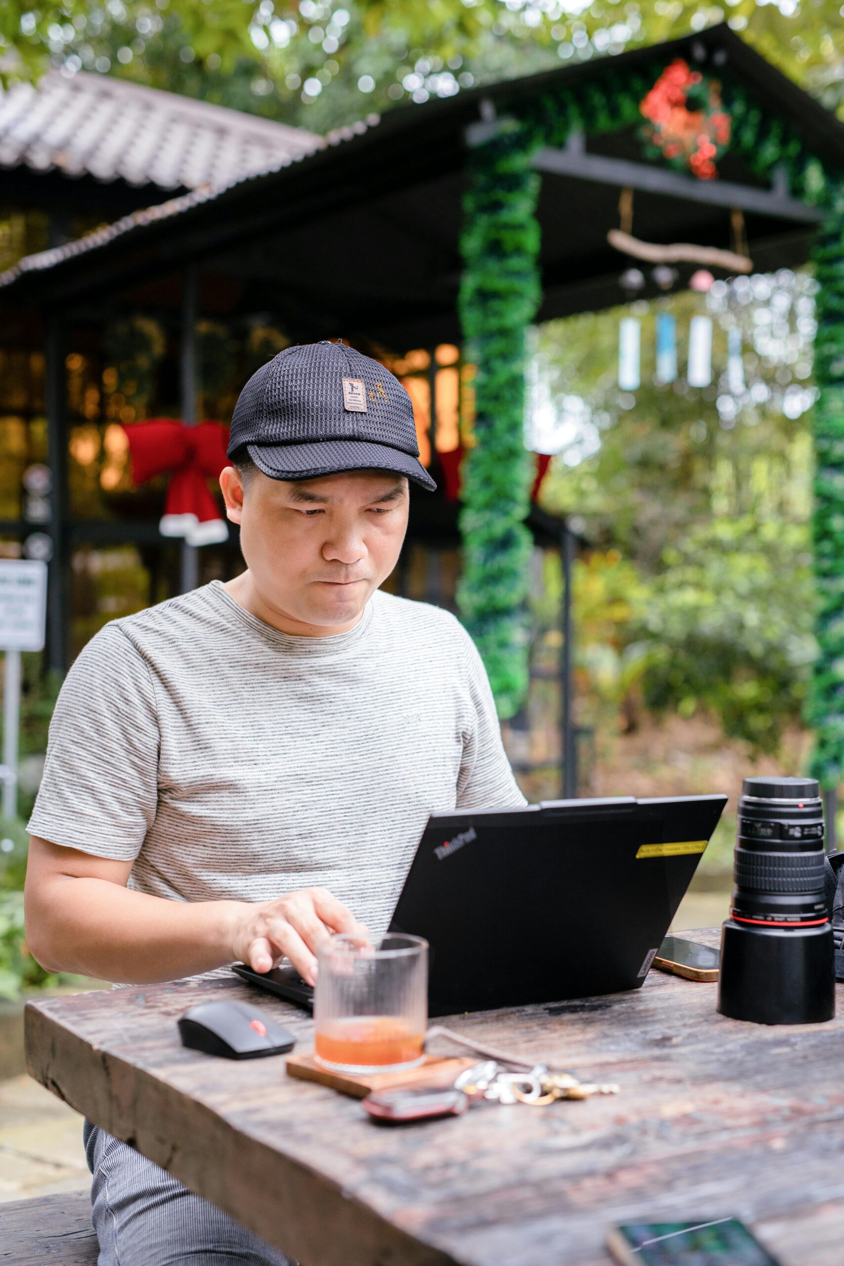 Man in casual clothing works on a laptop at an outdoor cafe in Bien Hoa, Vietnam.